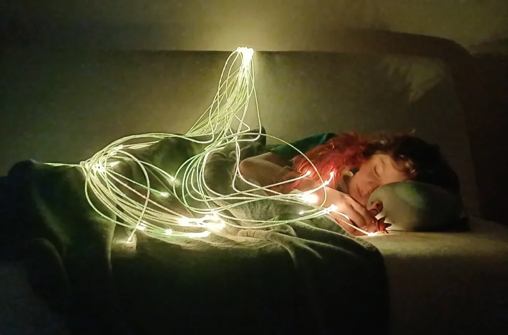Enfant apaisé sous des fibres optiques lumineuses dans un coin calme