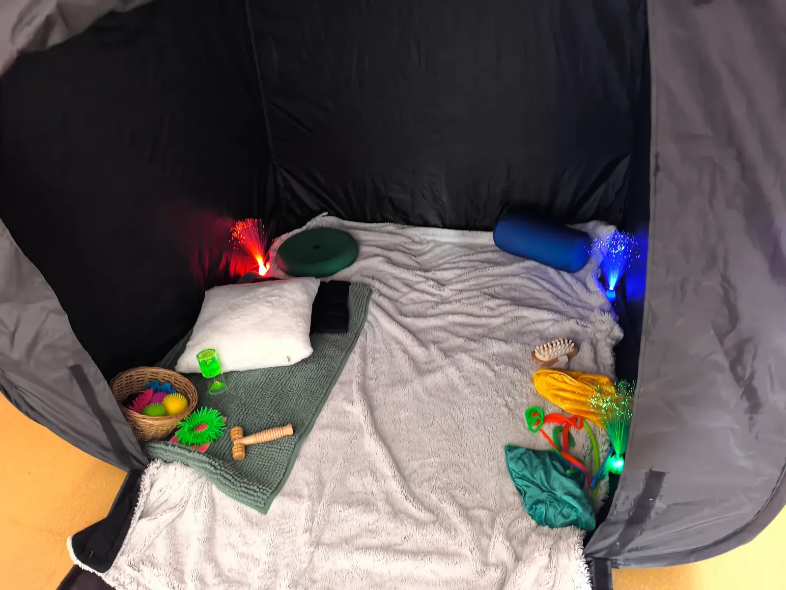 Cocon sensoriel douillet avec coussins et objets à manipuler